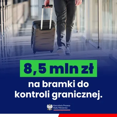 Człowiek w dżinsach i trampkach ciągnie małą walizkę na kółkach przez nowoczesny korytarz z dużymi oknami.